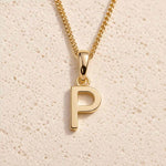 Close-up of gold initial necklace with a P letter charm on a fine gold chain; a letter charm option to personalise Necklaces