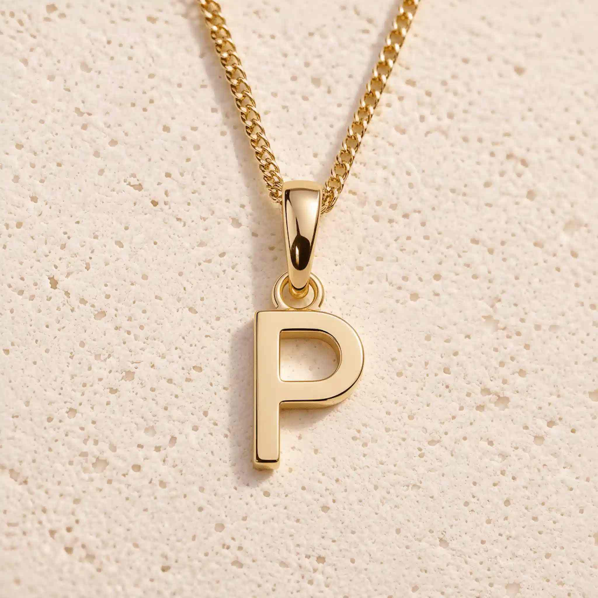 Close-up of gold initial necklace with a P letter charm on a fine gold chain; a letter charm option to personalise Necklaces