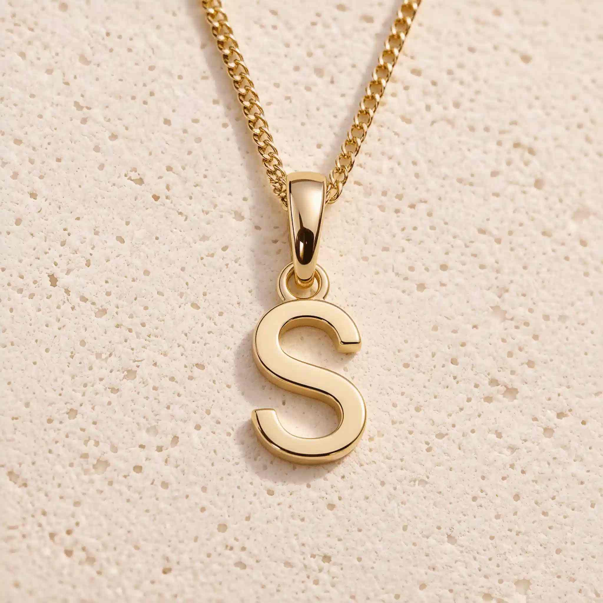 Close-up of gold initial necklace with a S letter charm on a fine gold chain; a letter charm option to personalise Zodiac and Birthstone Necklaces