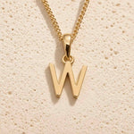 Close-up of gold initial necklace with a  W letter charm on a fine gold chain; a letter charm option to personalise Zodiac and Birthstone Necklaces