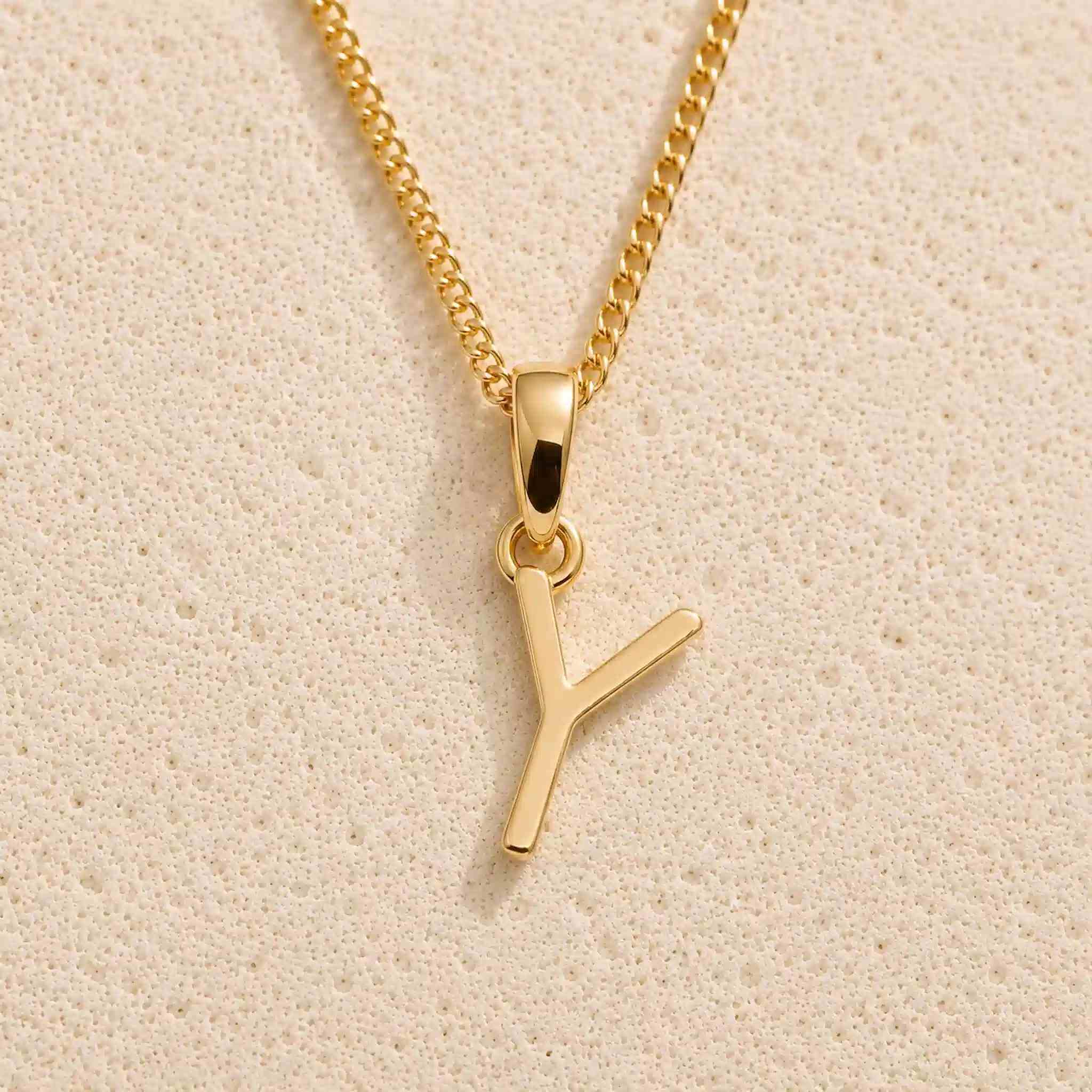 Close-up of gold initial necklace with a  Y letter charm on a fine gold chain; a letter charm option to personalise Zodiac and Birthstone Necklaces