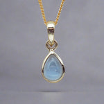 gold November Birthstone necklace with pear-shaped natural blue topaz gemstone pendant