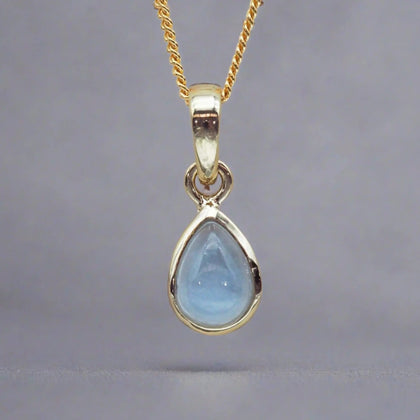 gold November Birthstone necklace with pear-shaped natural blue topaz gemstone pendant