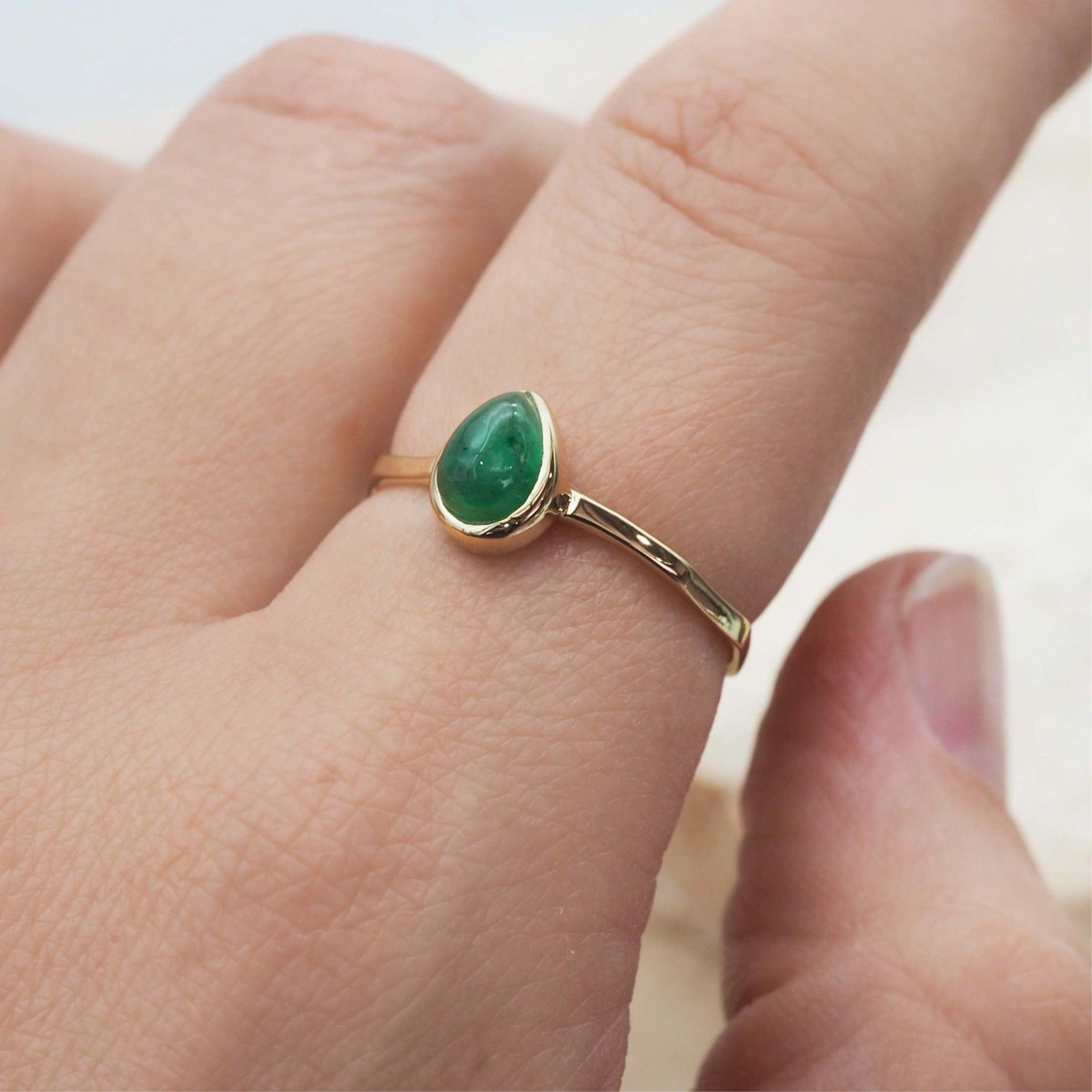 finger wearing gold May Birthstone emerald Ring by indie and harper australia