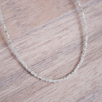 sterling silver Necklace with natural rainbow moonstone beads on a wooden surface