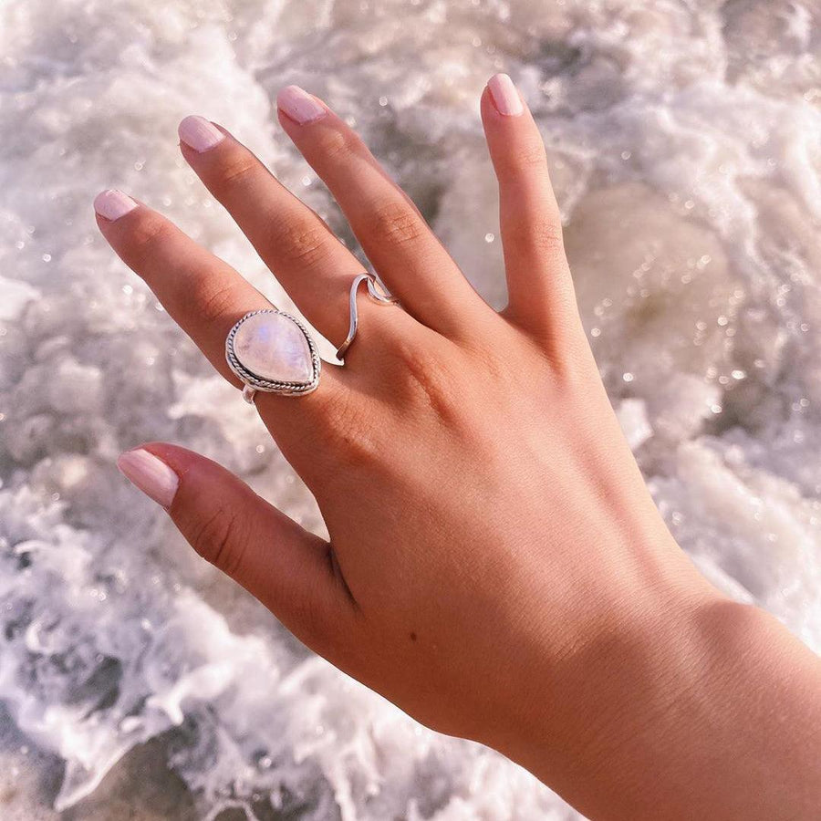 woman with hand over crashing ocean waves wearing silver wave ring and moonstone ring - womens moonstone jewellery australia
