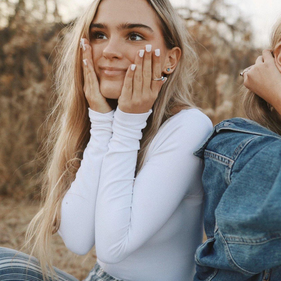 Girl with blonde hair and white top wearing November Birthstone jewellery