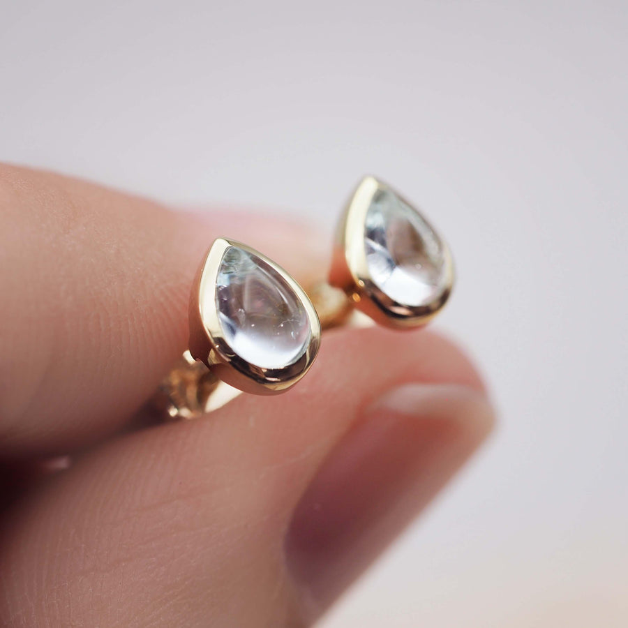 Fingers holding pair of November Birthstone Earrings made with gold and Topaz - Australian jewellery brand