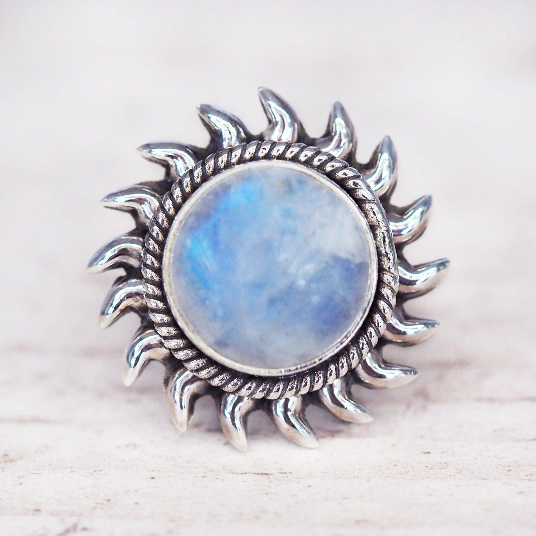 sterling Silver sun-shaped ring with a central moonstone gemstone on a light wooden background