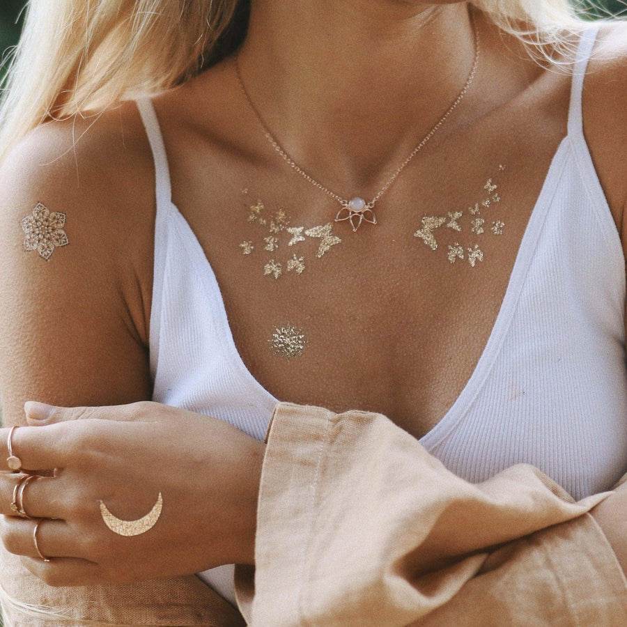 Woman with gold temp tattoos wearing rose gold necklace 
