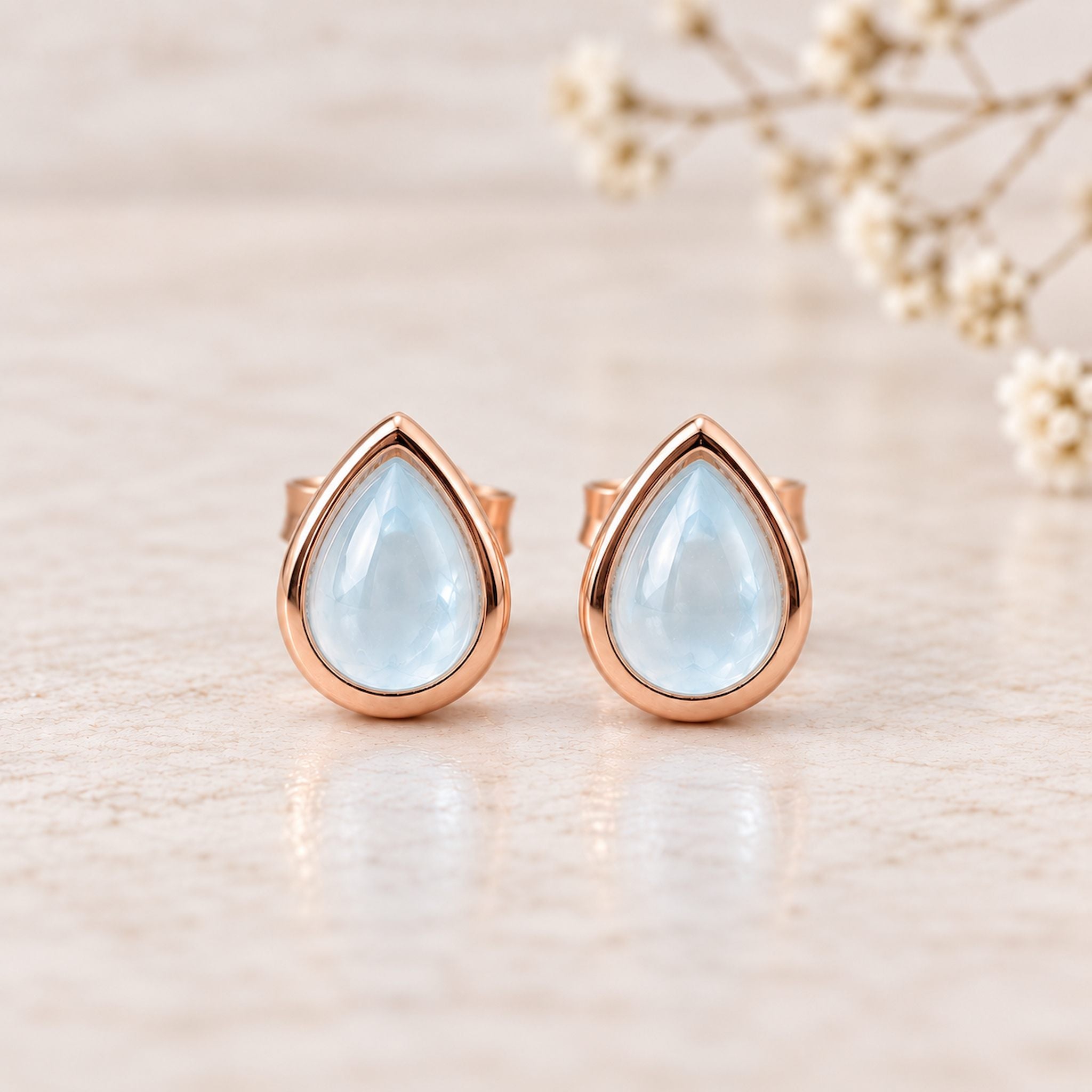 Rose Gold November Birthstone Earrings with pear-shaped natural blue topaz gemstones