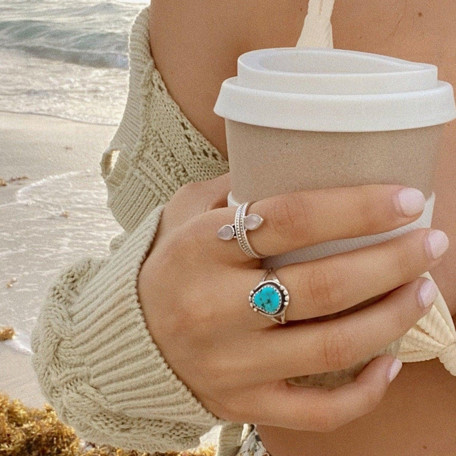 Woman holding coffee cup wearing turquoise ring and Rose Quartz Ring - womens boho jewellery by indie and harper