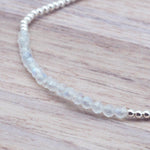 close up of a Sterling silver Moonstone beaded Bracelet on a light wooden surface