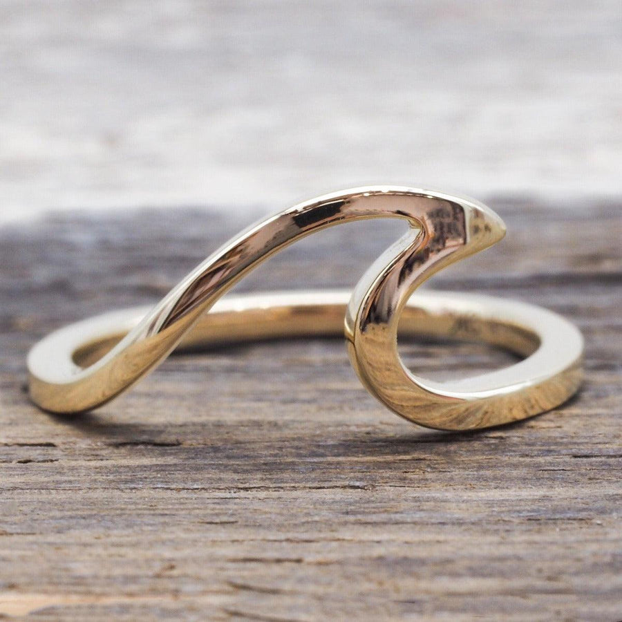 Solid 9ct Gold Wave Ring sitting on wood - womens gold rings australia