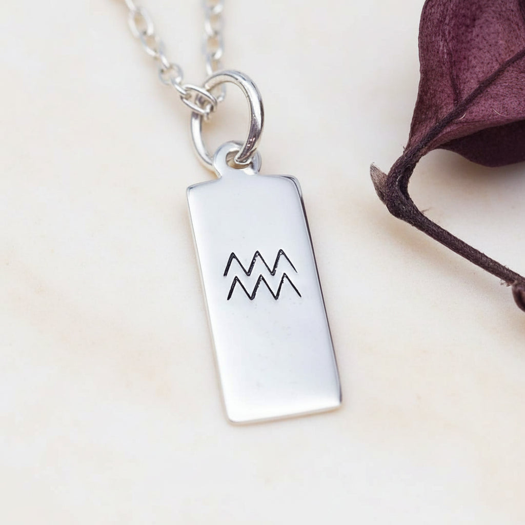sterling Silver necklace with a rectangular aquarius zodiac pendant on a neutral background