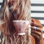 Woman holding a pink tea cup wearing double band moonstone ring by indie and harper Australia 