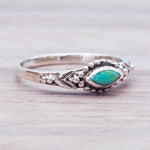 Silver ring with a turquoise stone on a wooden surface