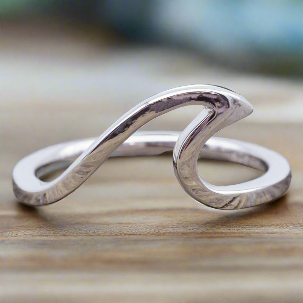 sterling silver wave ring on wooden surface