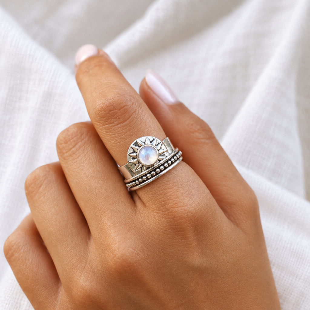 Hand wearing a sterling silver sunrise rainbow moonstone ring, close-up
