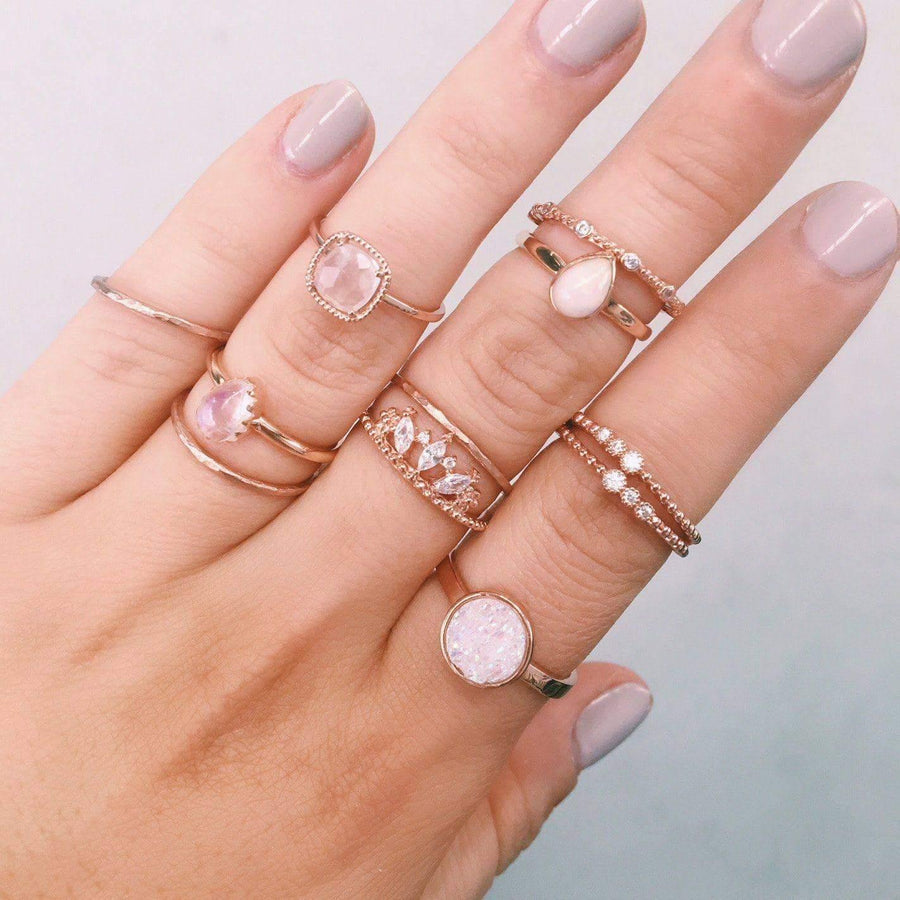 Woman’s hand wearing multiple rose gold rings