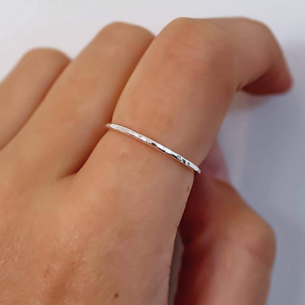 Silver ring on a person's finger against a white background