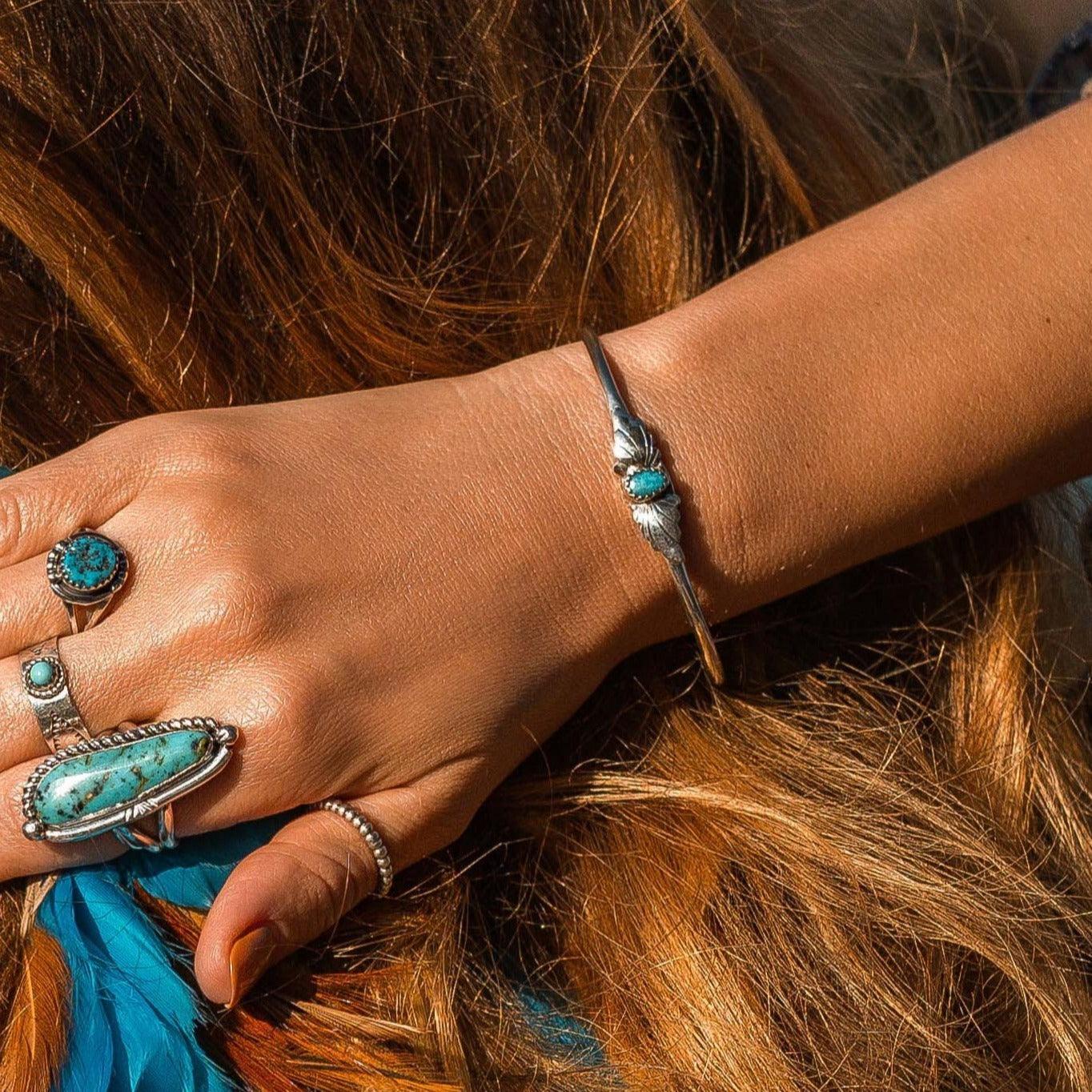 Woman wearing Navajo Turquoise bracelet and turquoise rings - native american jewelry by indie and harper australia
