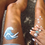 Girls leg with painted wave picture and wearing Cowrie Sea Shell Ring - indie and harper