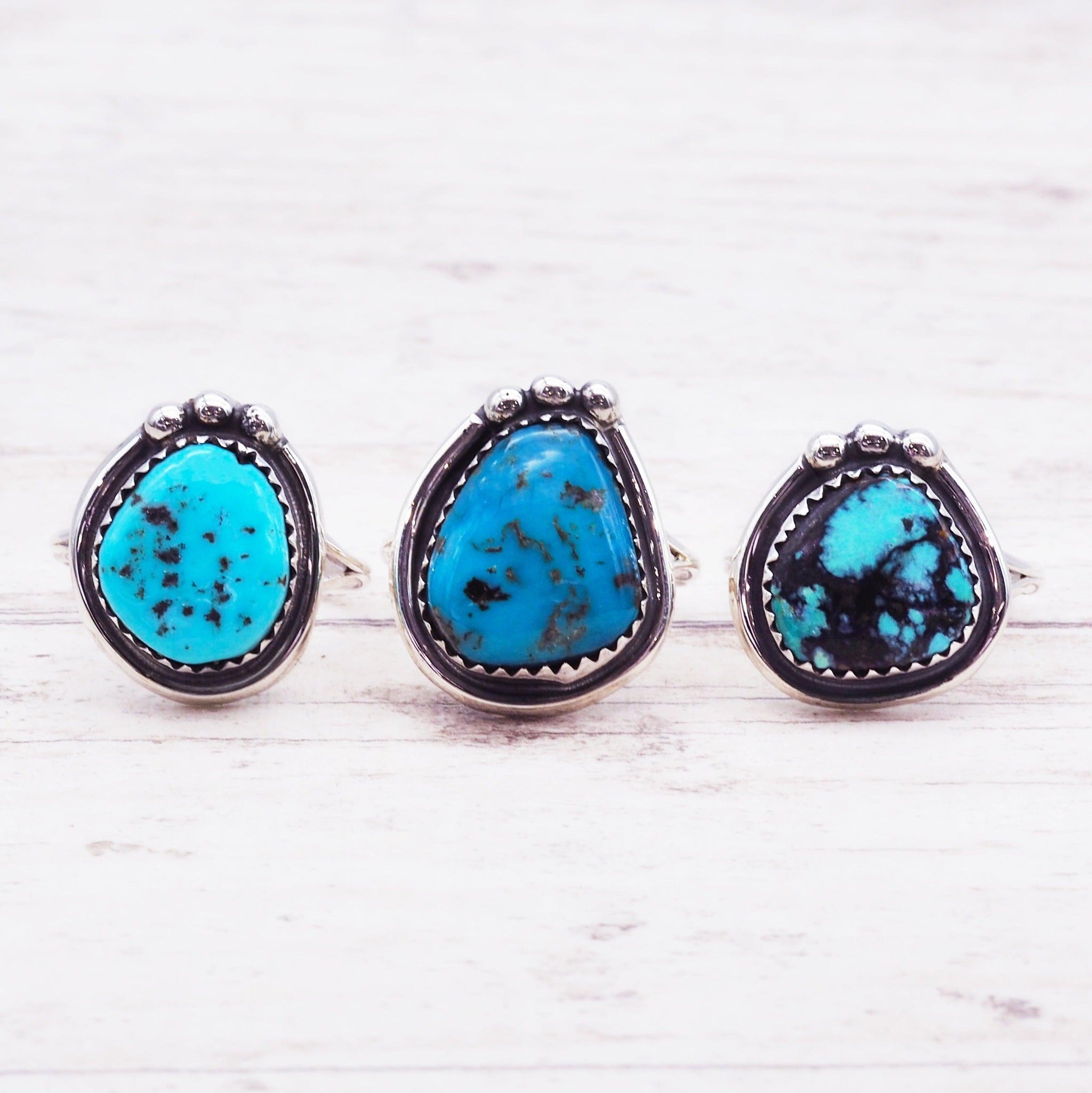 Navajo sterling silver Turquoise Rings on a light wooden surface